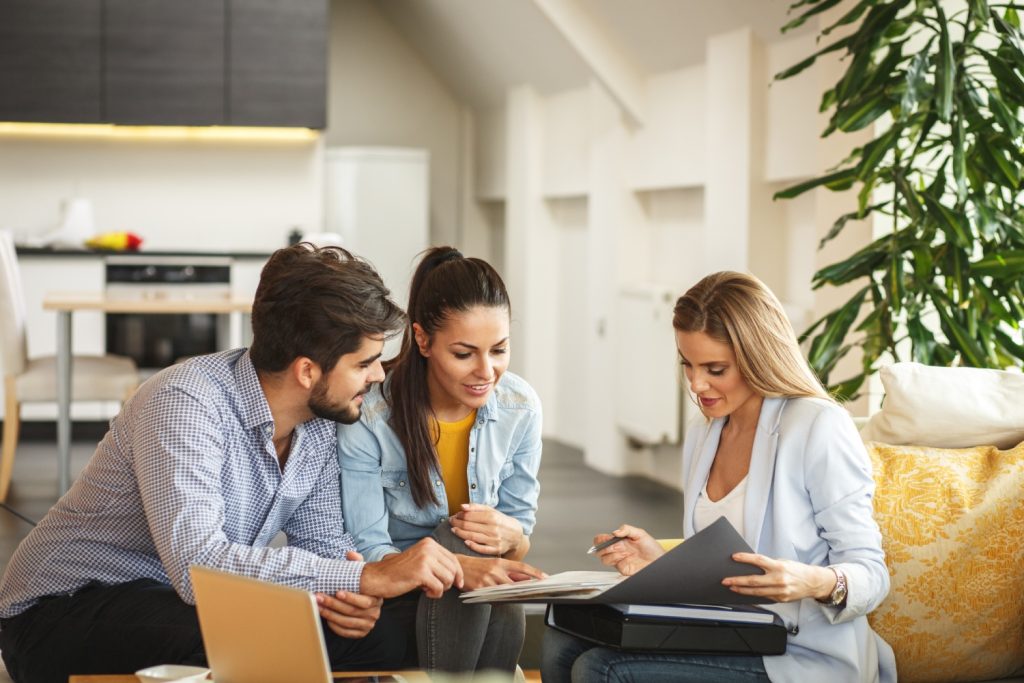 Female Real Estate agent offers home ownership and life insurance to young couple