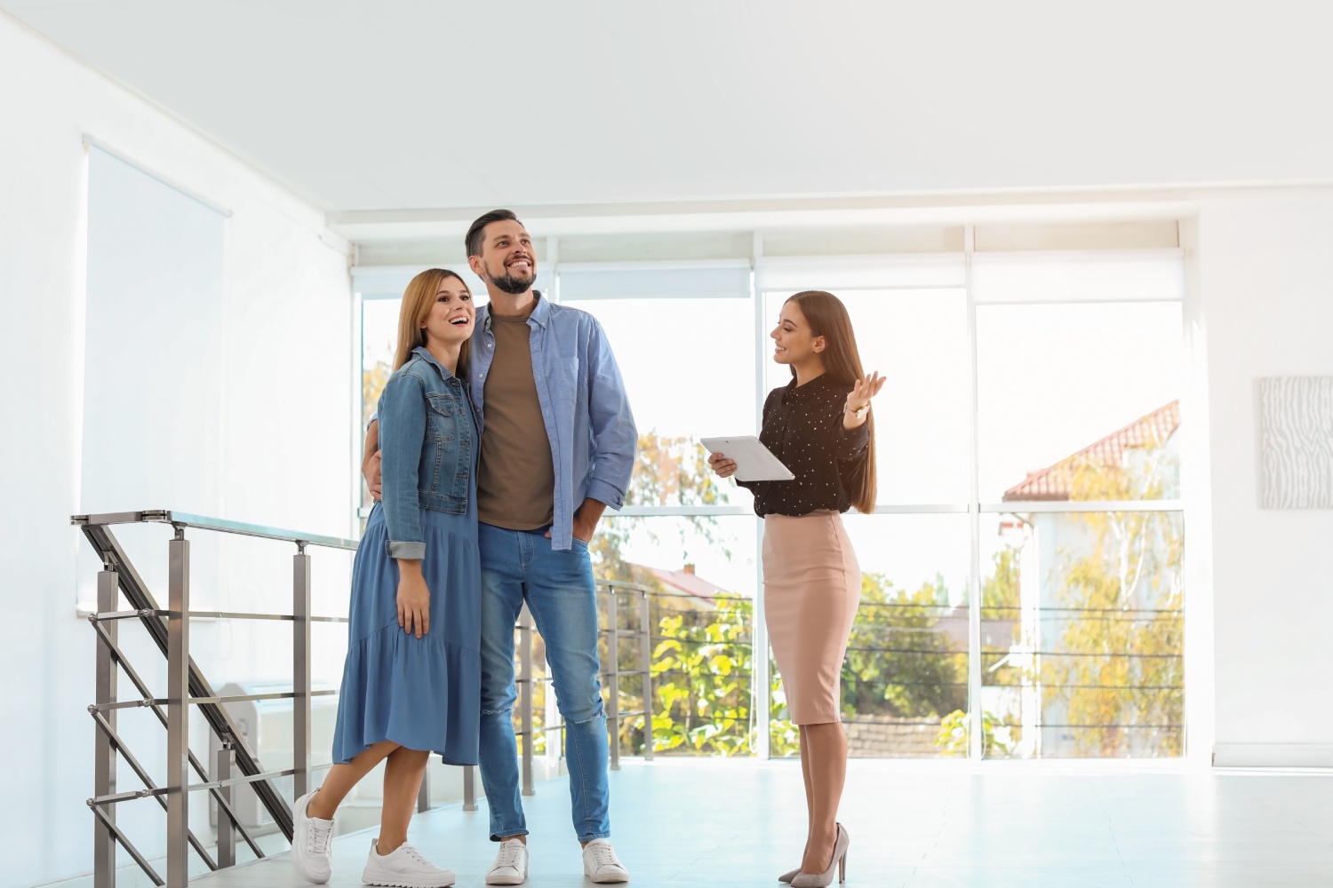 Female real estate agent showing new house to couple, indoors
