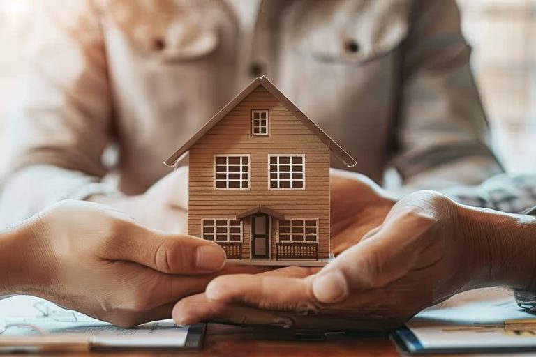 Real estate agent passing a miniature house model to a client during a meeting, discussing property purchase, mortgage, loan, and investment opportunities.